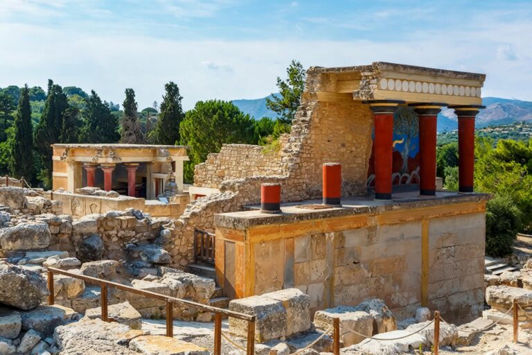 Restored red columns and archaeological ruins at the Palace of Knossos in Crete
